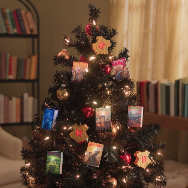 A miniature Christmas tree is strung with a strand of lights that feature all seven books from the Harry Potter series, sculpted in miniature and lit from within.