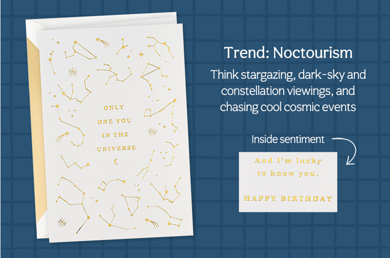 A white card with gold embossed constellations and stars on the front, with a similarly embossed message that reads,