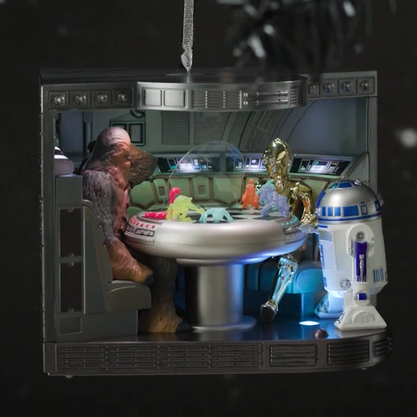 A Keepsake Ornament portraying a scene in Star Wars: A New Hope, in which Chewie and R2-D2 play holochess as C-3PO looks on.