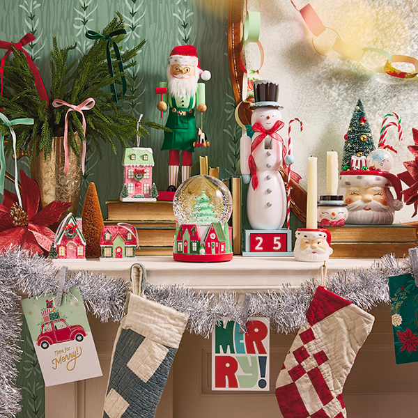 A collection of vintage-inspired Christmas decorations adorn a fireplace mantel that's been decorated for the holiday season.