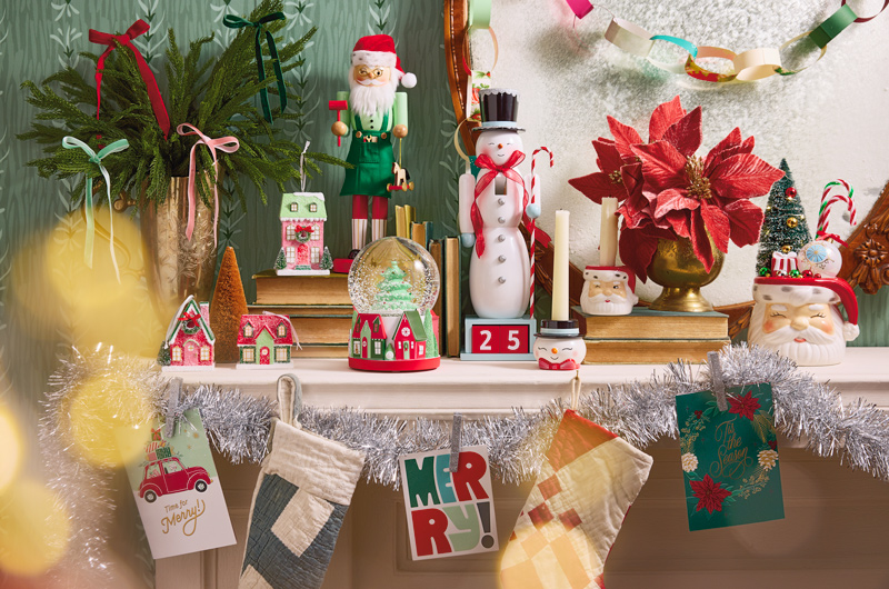 A collection of vintage-inspired Christmas decorations adorn a fireplace mantel that's been decorated for the holiday season.
